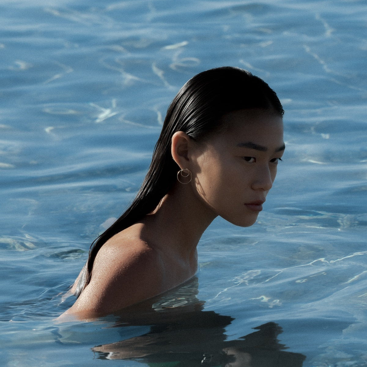 Person with long hair partially submerged in water