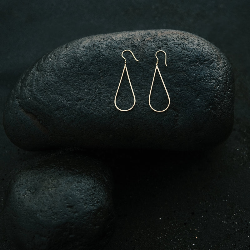 The raindrops earrings in gold plated silver, in the shape of a minimal raindrop, by jewelry designer Aurore Havenne