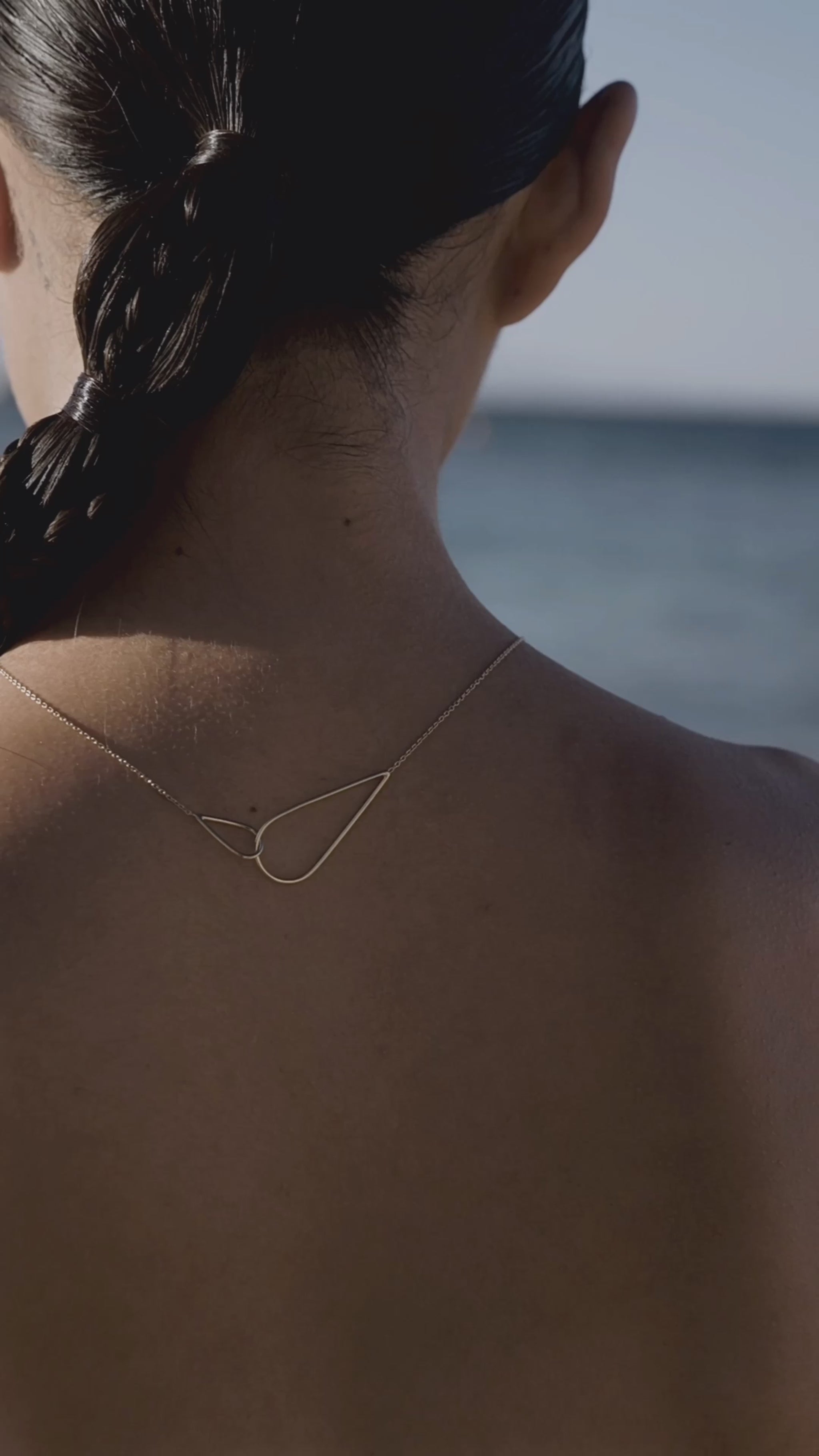 Une femme à la mer porte le collier Raindrops en argent plaqué or