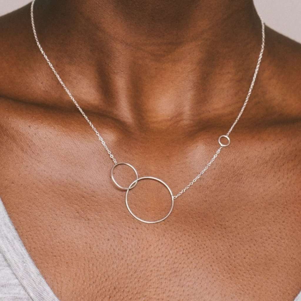 Photo of a model who is wearing the silver Trinity necklace. The Trinity necklace is made of 925°°° silver.