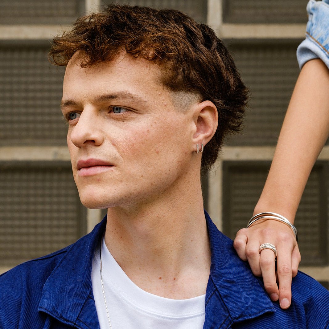 Black and white photo of male model Jasper Derluyn who is wearing the Jasper earrings, by jewelry designer Aurore Havenne.