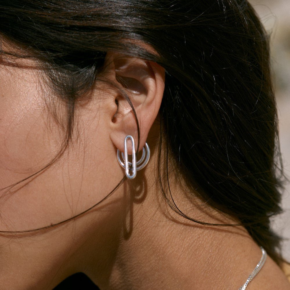 Outdoor photo of a model wearing the silver Séléné earrings. These earrings are made of 925°°° silver.