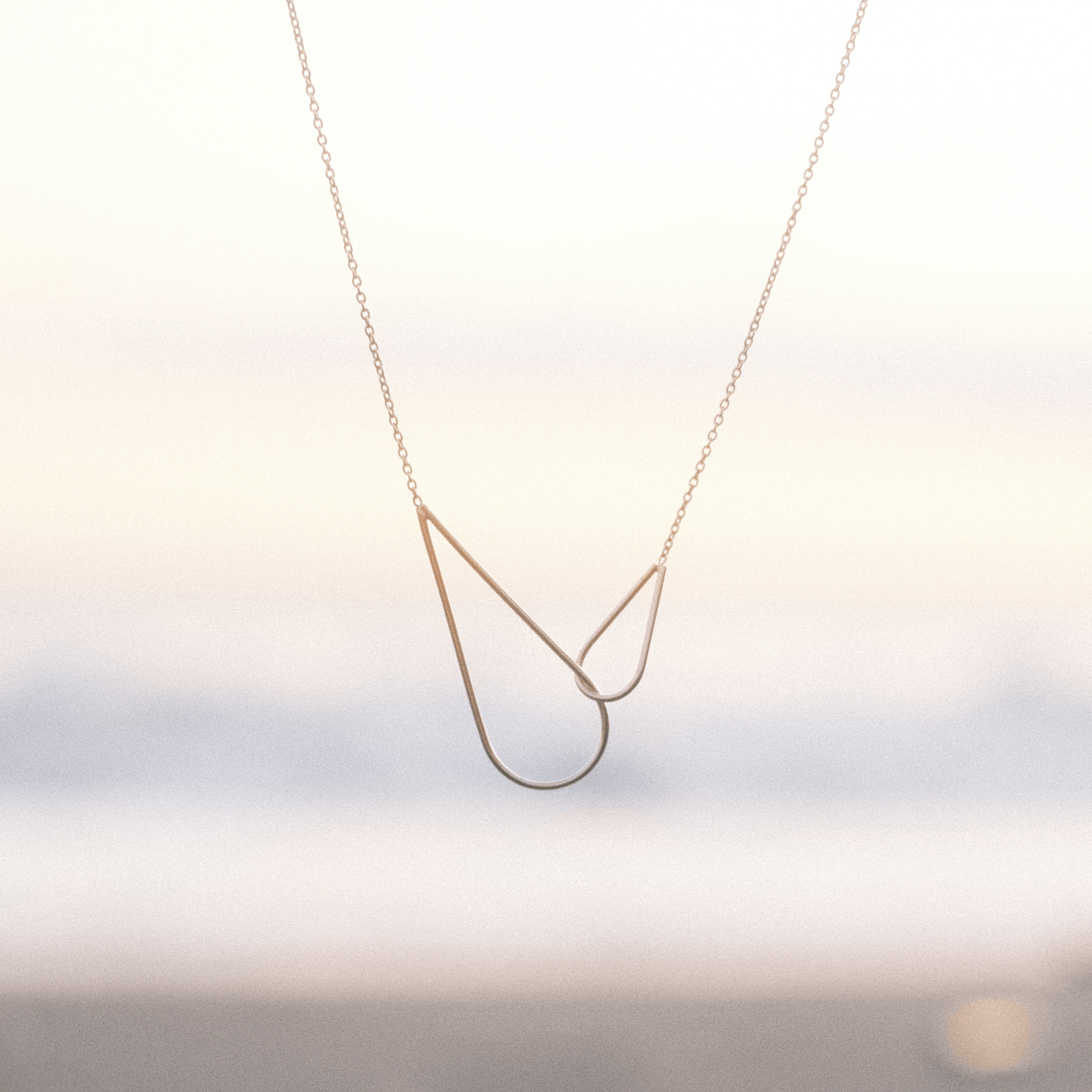 Le collier Raindrops Aurore Havenne, sur un fond de coucher de soleil à Bali